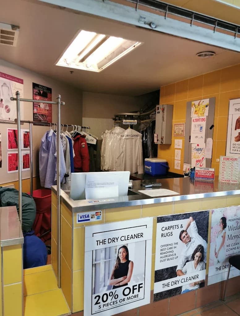 Inside The Dry Cleaner, with garments pressed and protected on the rack behind the counter